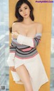 A woman in a white dress posing for a picture.