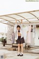 A young girl standing in front of a rack of clothes.