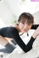 A woman laying on top of a white couch.